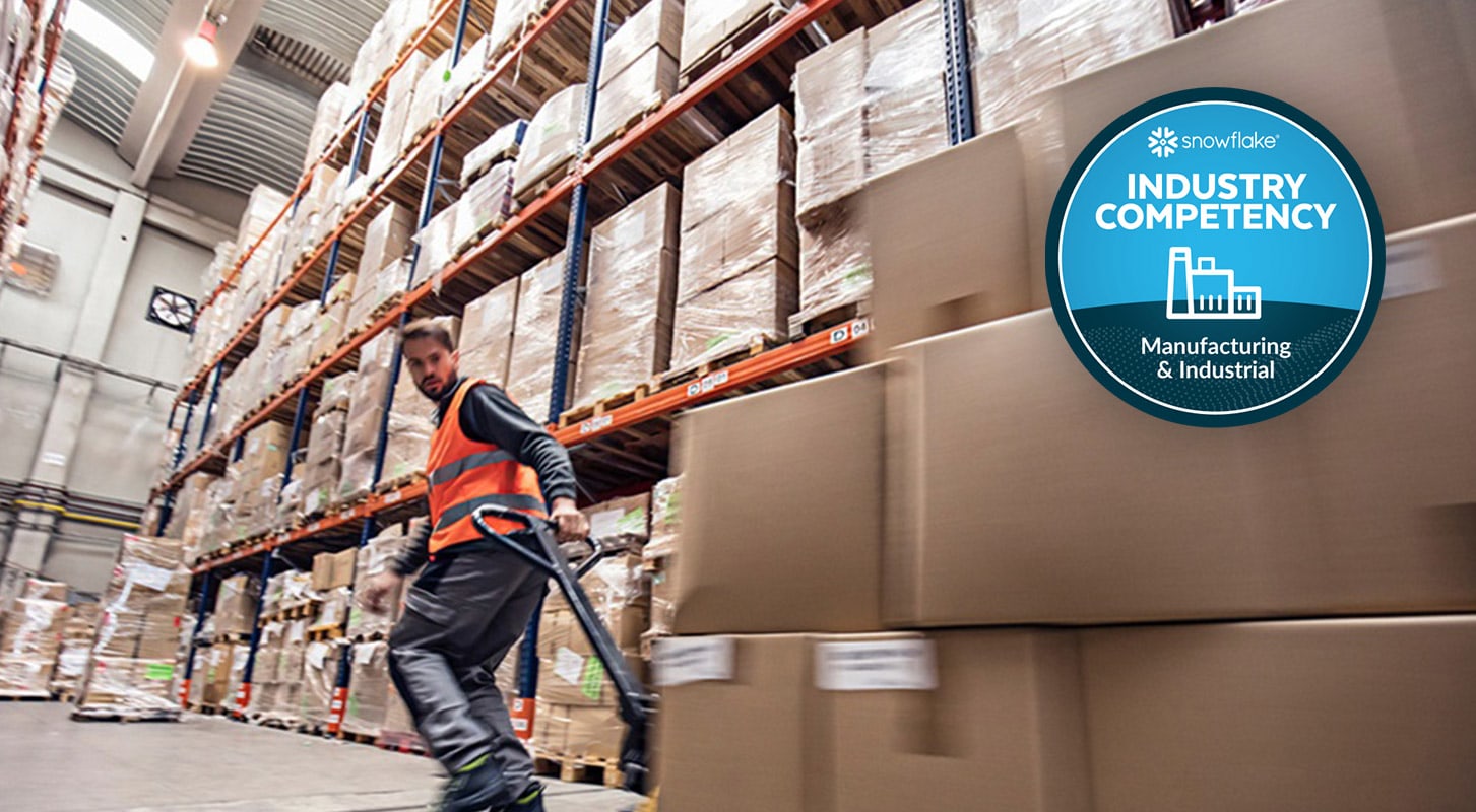 Um funcionário do armazém usando um colete de segurança laranja move caixas com uma paleteira. O emblema "Industry Competency: Manufacturing & Industrial" é exibido no canto superior direito.